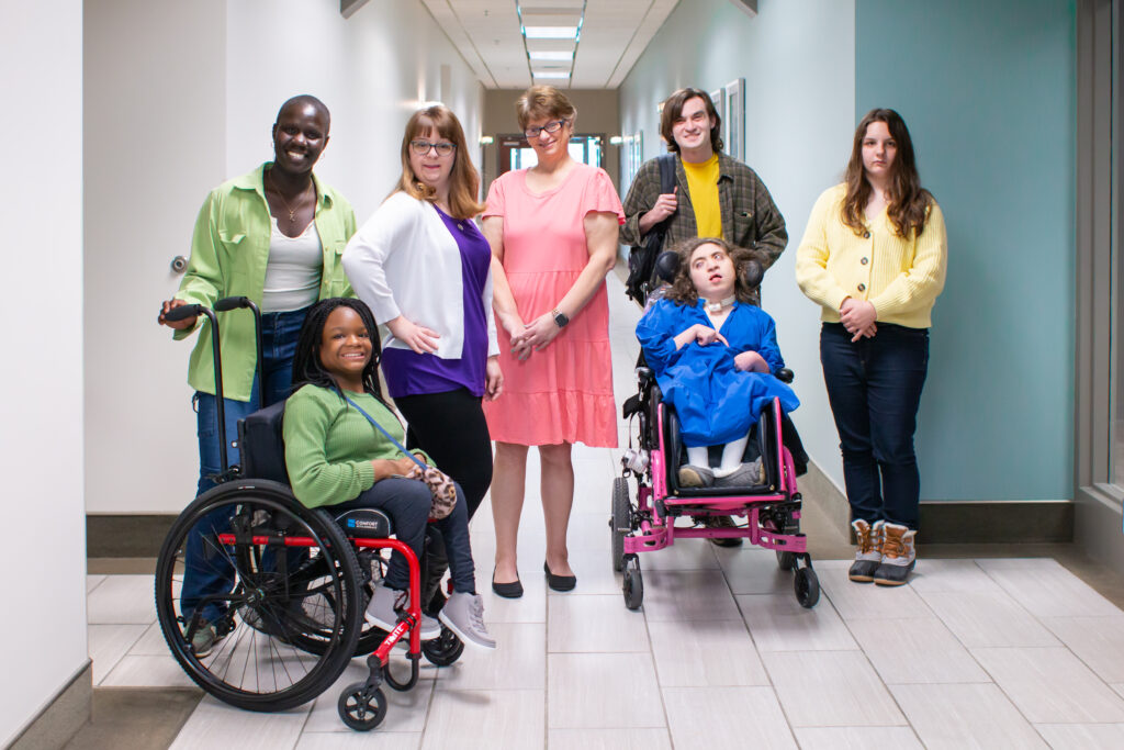 People with disabilities and their supporters are in a hallway