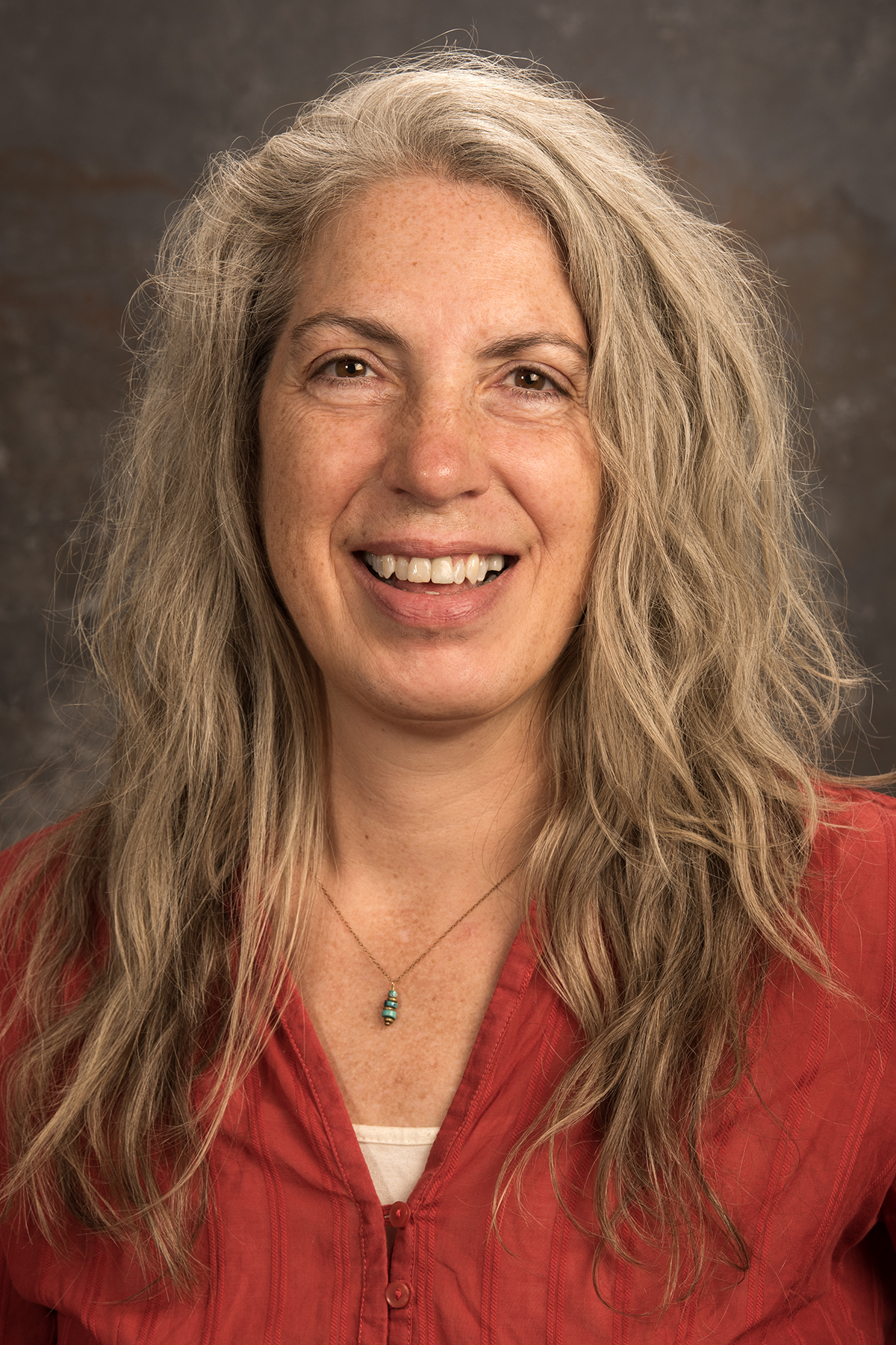 A smiling woman with wavy hair